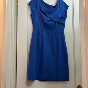 Firm fitting sheath with an asymmetrical neckline